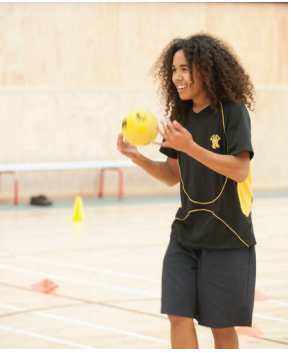 This image is a photo of a male student preparing to throw a ball in the gym